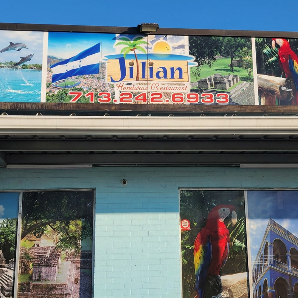 Jilian Honduran Restaurant storefront with colorful sign, tropical murals, parrots, dolphins, and Mayan and colonial architecture.